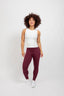 women wearing maroon burgendy leggings with ribbed white sleevless crop tank top