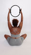 Woman seated with pilates circle in grey non-toxic bike shorts and cross-back sports bra