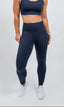Woman wearing a navy blue sports bra and leggings performance exercise set
