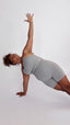 Women wearing gray yoga set with bike shorts and bra doing side plank